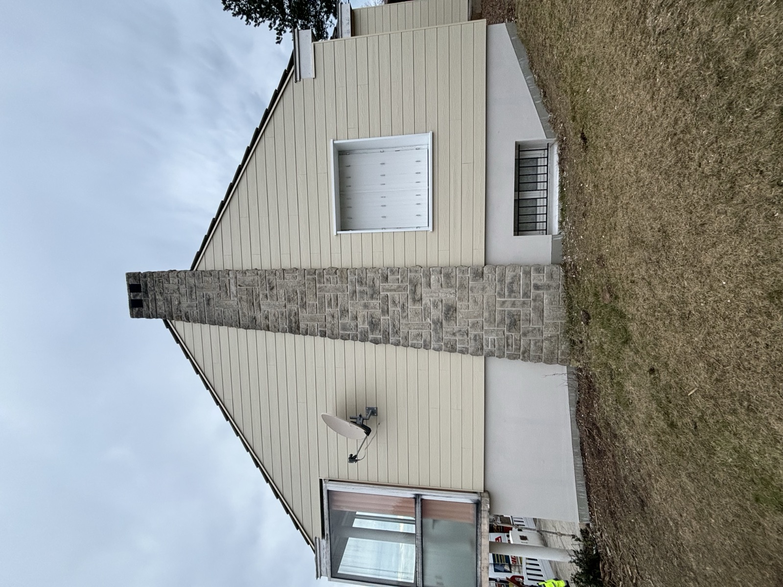 Cheminée habillée de parement pierre reconstituée sur façade beige — Dagicour Normandie