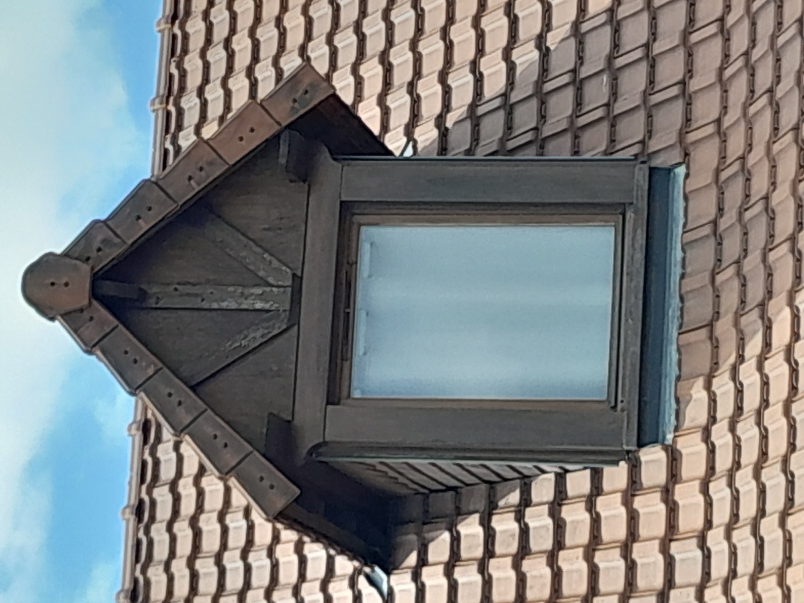 Détail d'une lucarne en bois massif habillée et tuilée, finition charpente sur-mesure Dagicour