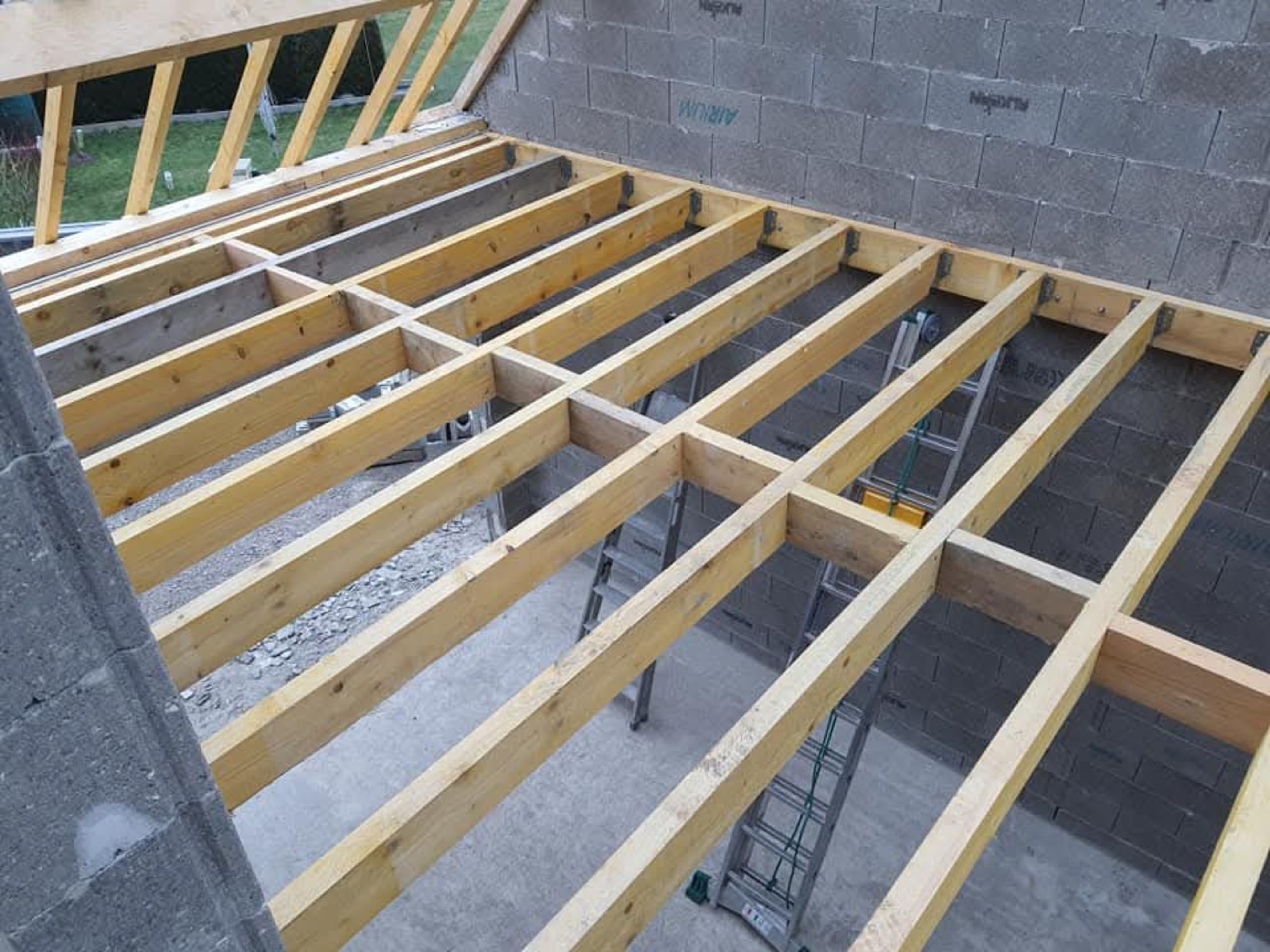 Solivage bois d'un plancher en cours de montage sur murs en parpaing — chantier Dagicour