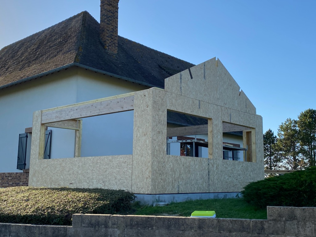 Avant travaux : ossature bois de l'extension en cours de montage contre la maison