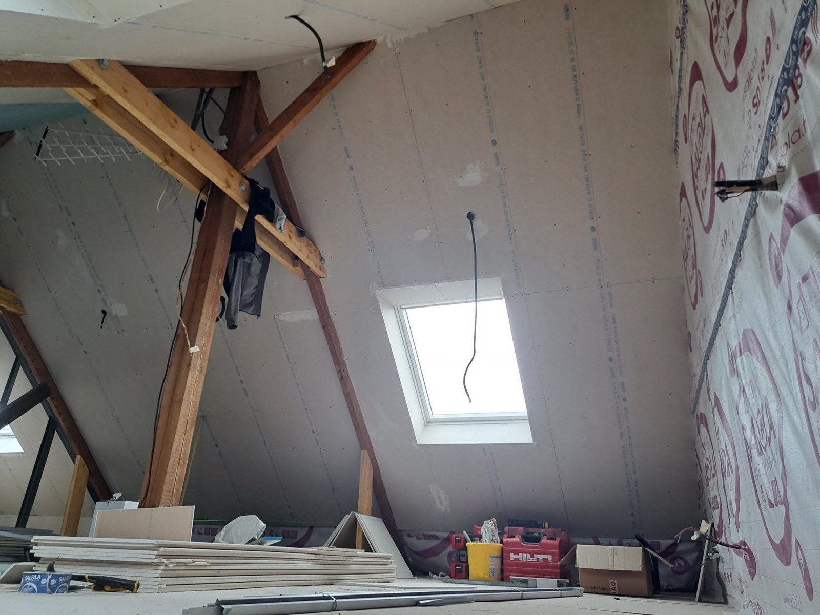 Ossature de charpente et membrane d'étanchéité à l'air sous une fenêtre de toit Velux, chantier isolation des combles Dagicour