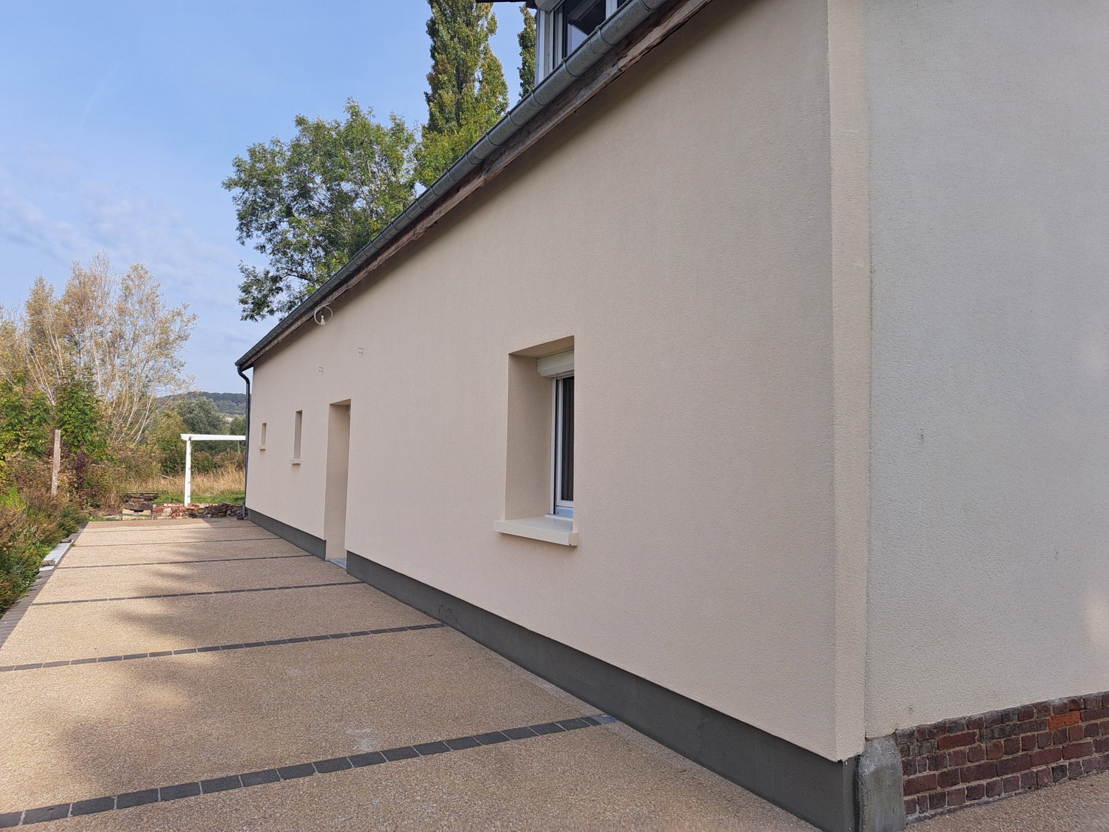 Après travaux : même bâtiment, mur enduit beige et isolé par l'extérieur — Dagicour