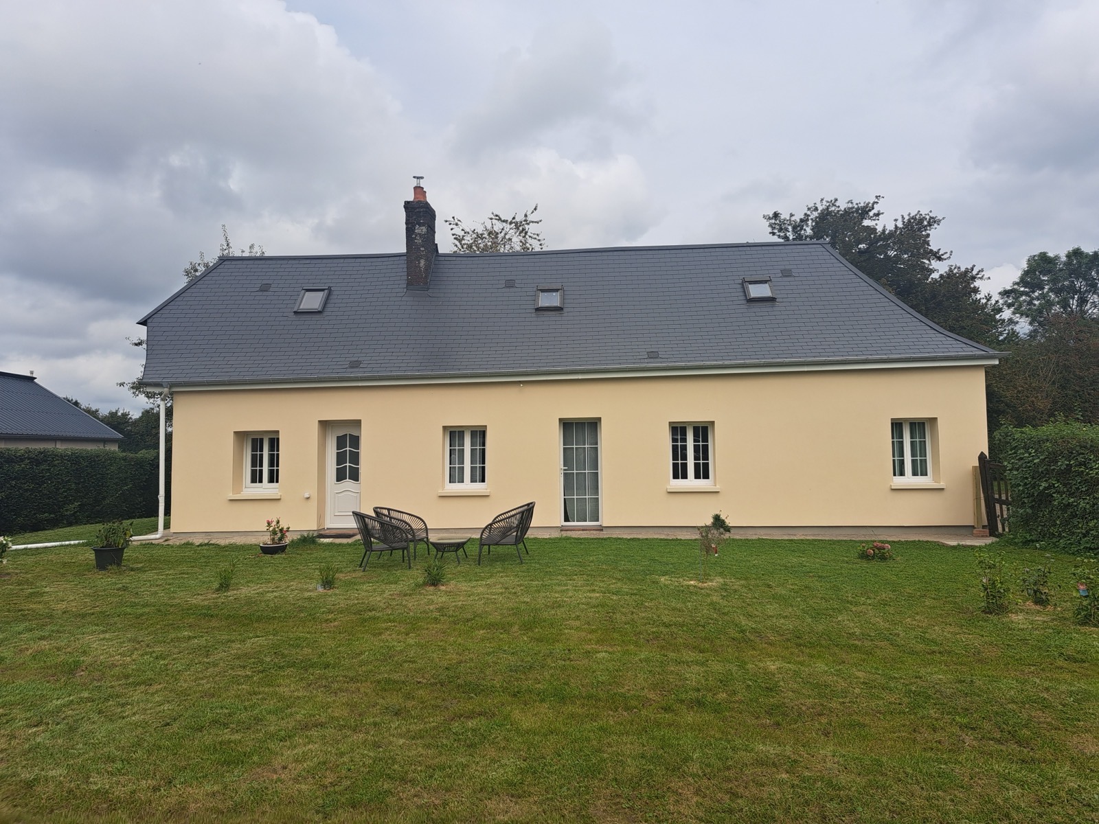 Façade isolée par l'extérieur avec enduit monocouche beige et soubassement foncé en Normandie — Dagicour