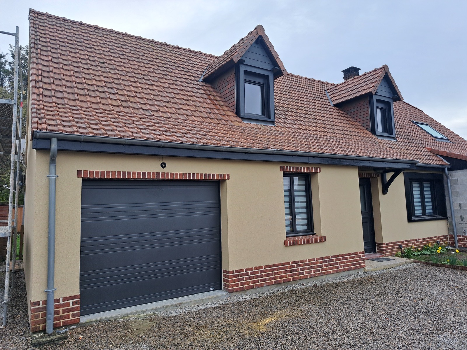 Maison neuve construite par Dagicour : façade enduite, soubassement briques, garage et lucarnes — gros œuvre et finitions soignées