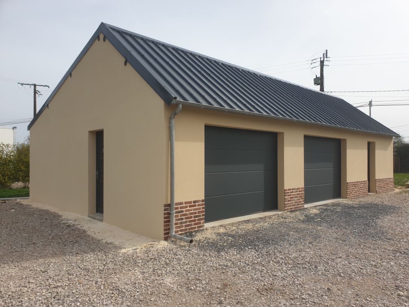 Garage double / local technique neuf construit par Dagicour, toiture bac acier anthracite et soubassement briques