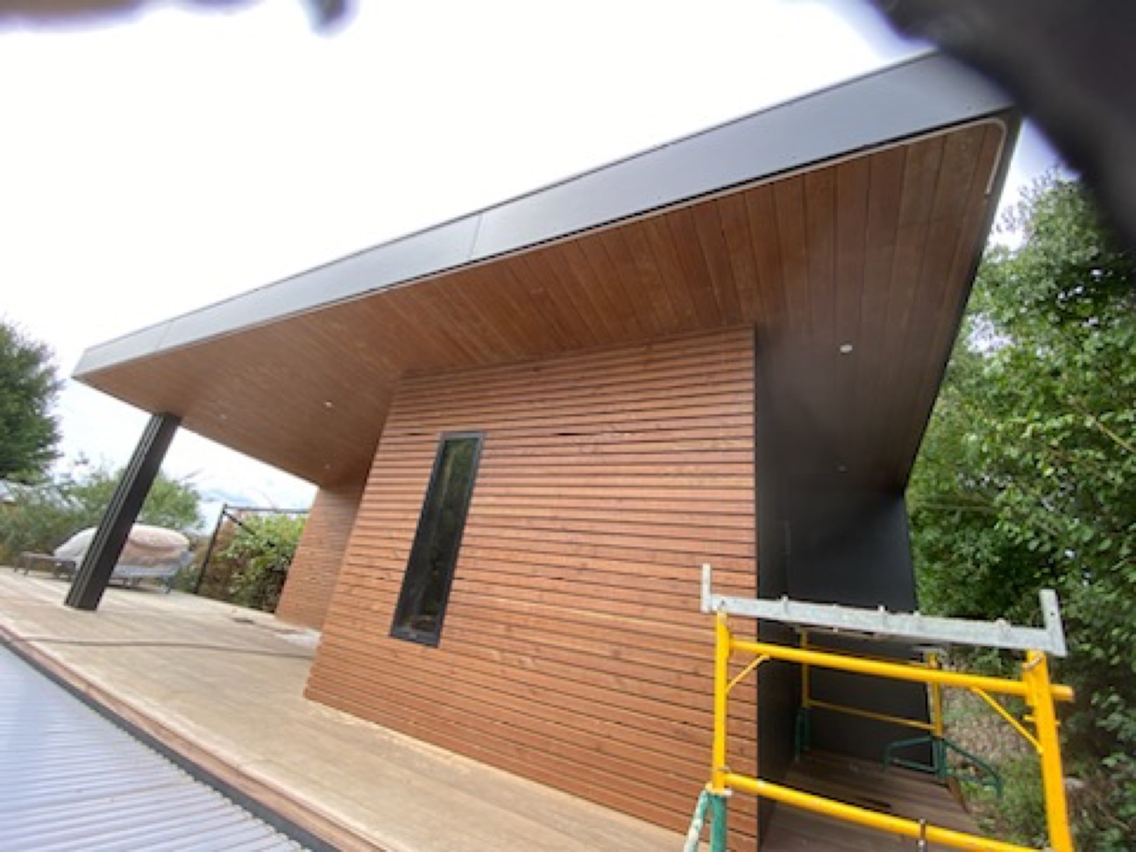 Espace extérieur couvert en bois avec large casquette de toit, idéal coin repas ou cuisine d'été — Dagicour