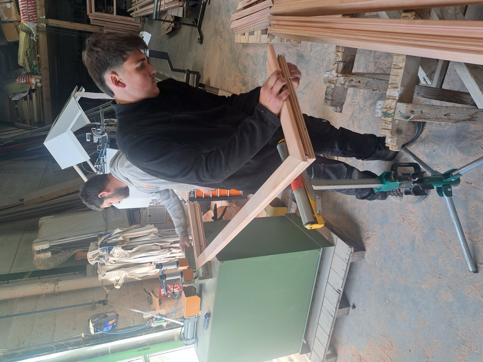 Menuisier Dagicour serrant un assemblage d'angle au serre-joint sur un cadre en bois — atelier Envermeu