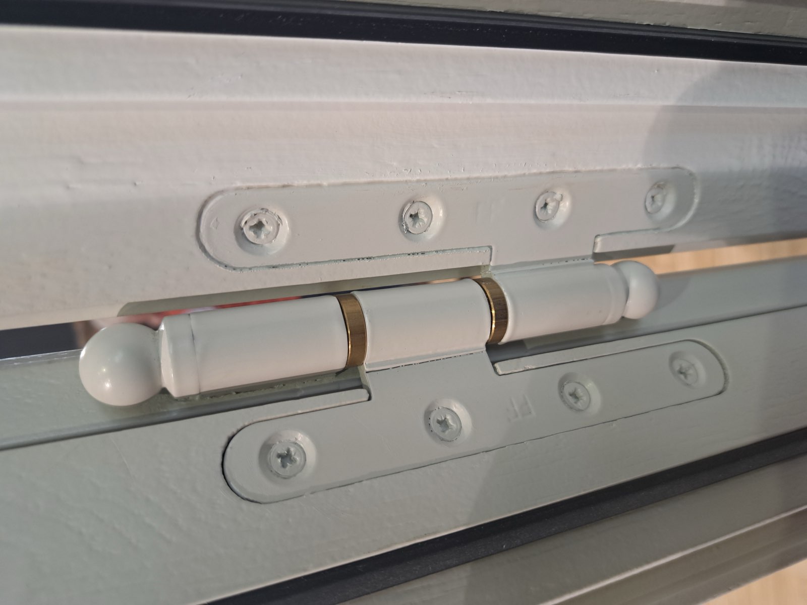 Détail d'une paumelle et de la quincaillerie d'une porte d'entrée en fabrication à Envermeu