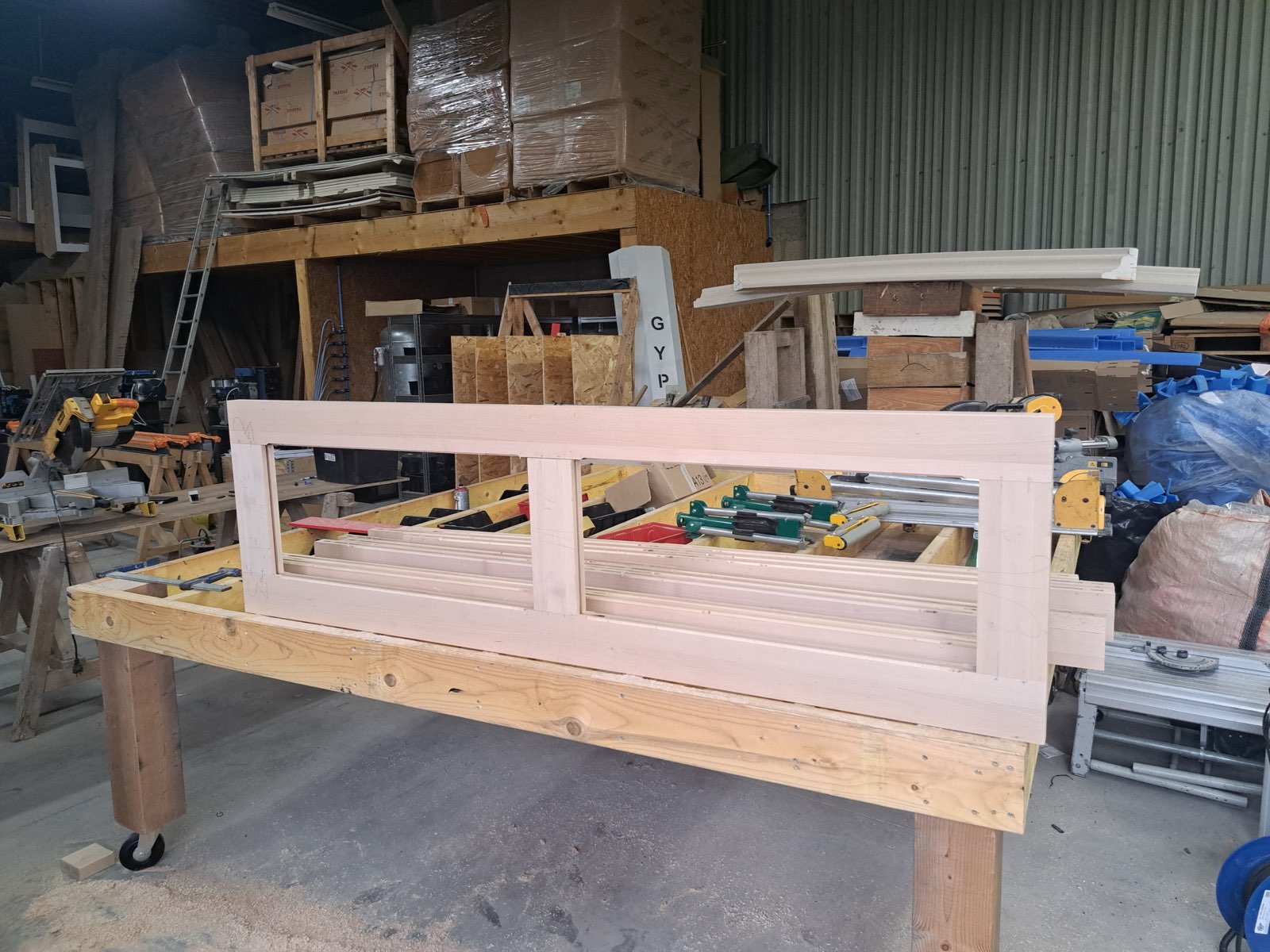 Porte d'entrée 2 vantaux en bois brut maintenue par des serre-joints, en cours de fabrication — atelier Dagicour