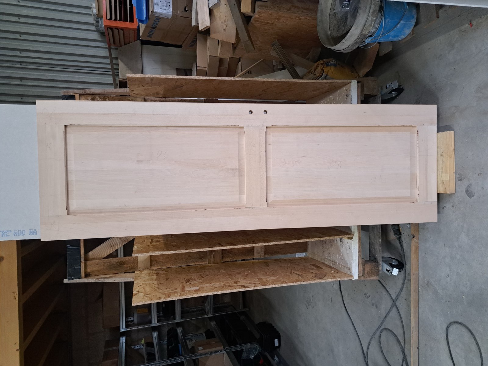 Porte d'entrée en bois brut en cours de fabrication sur établi — menuiserie Dagicour Envermeu