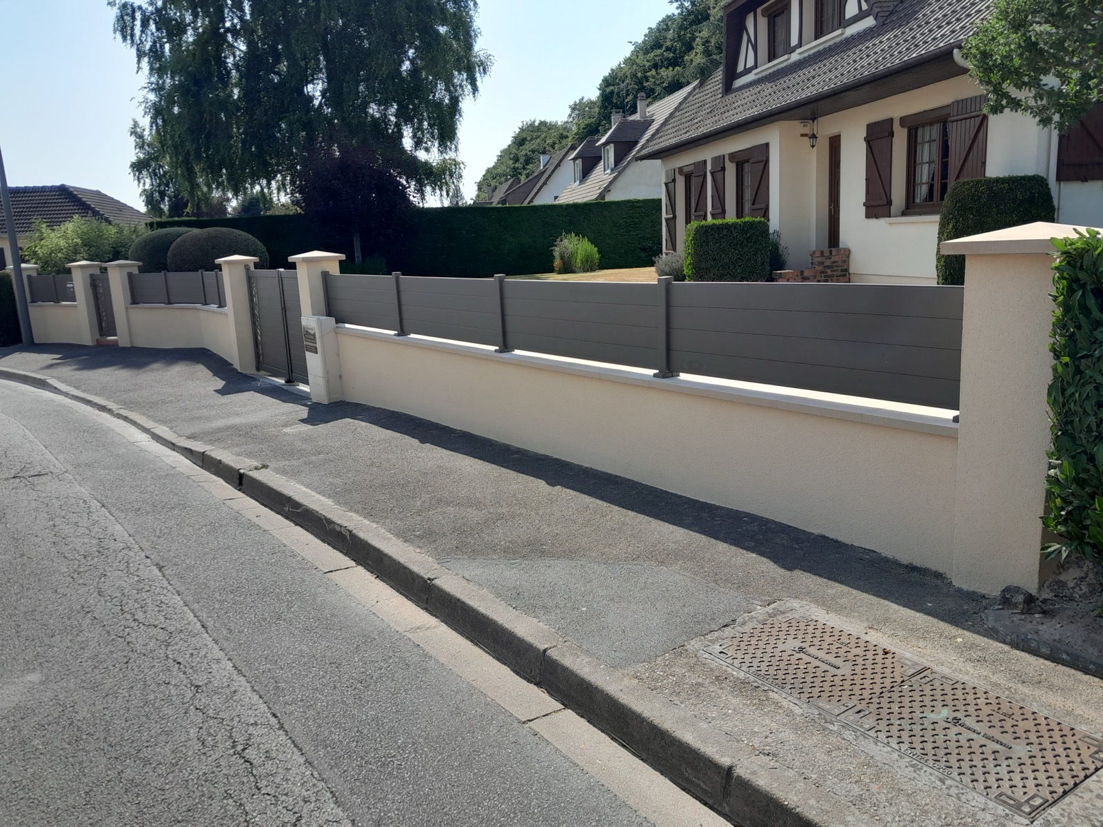 Après enduit : muret et piliers d'entrée finis en crépi crème, même chantier en Seine-Maritime