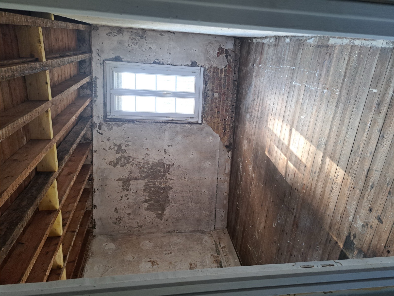 Pièce à l'état brut avant rénovation globale, murs décapés et plancher bois d'origine — chantier Dagicour Seine-Maritime