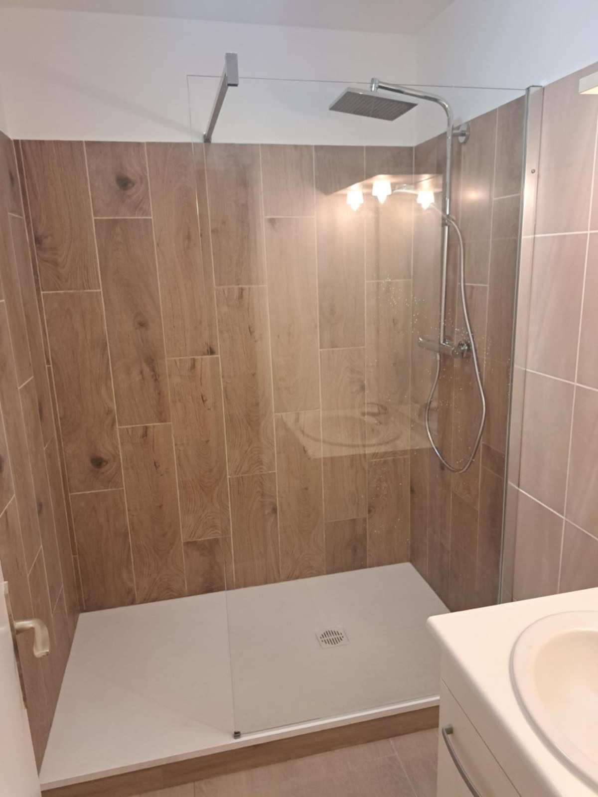 Exemple de finition livrée par Dagicour : salle de bain entièrement refaite à neuf, douche italienne carrelage imitation bois