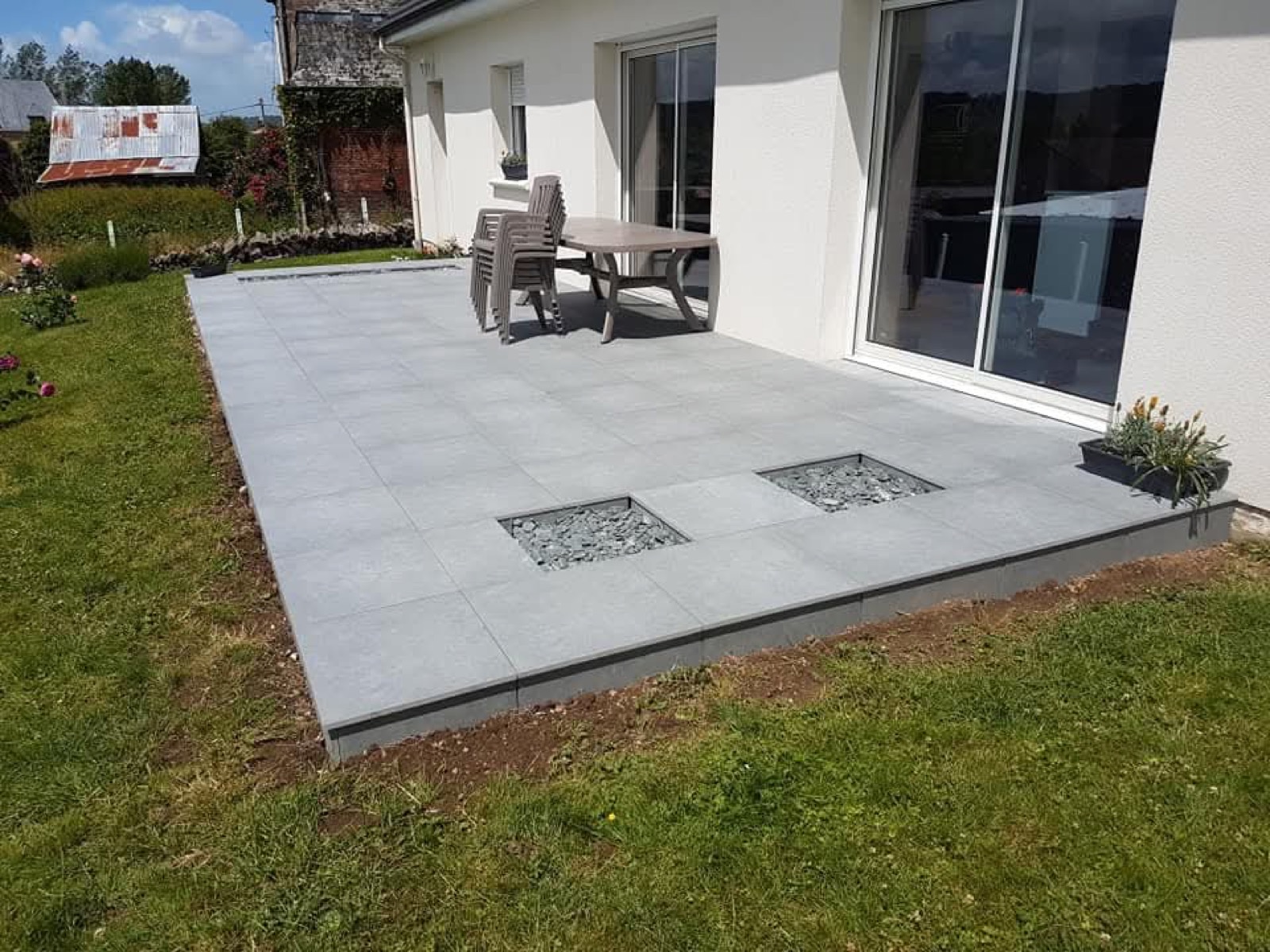 Terrasse en carrelage extérieur gris avec joints drainants et mobilier de jardin — Dagicour