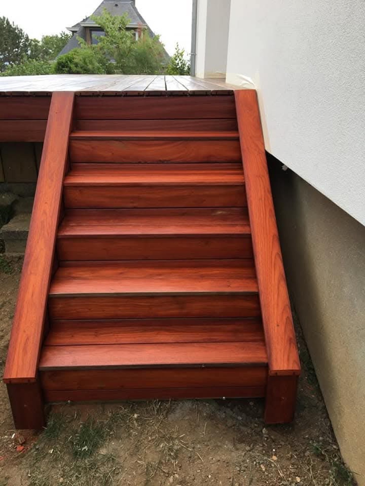 Escalier de terrasse en bois exotique teinté rouge, finition soignée — Dagicour