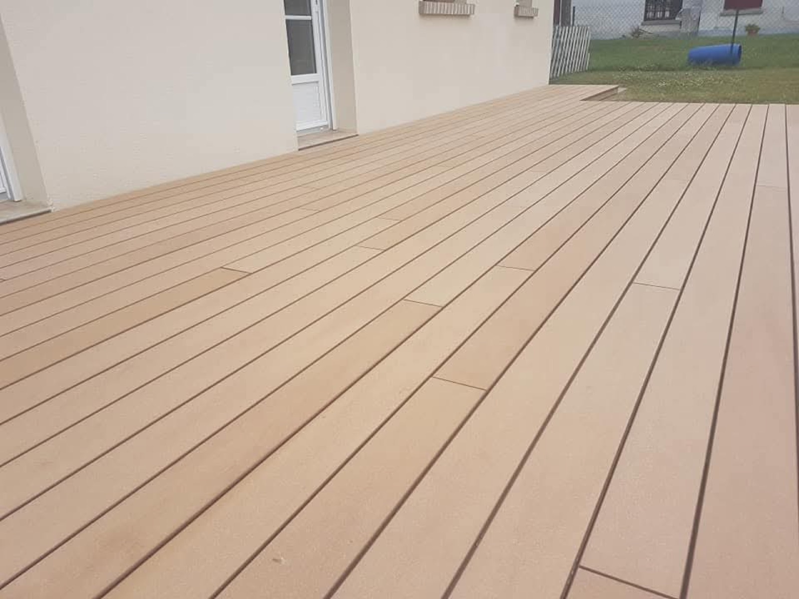 Terrasse composite beige épurée le long d'une maison en Seine-Maritime — Dagicour