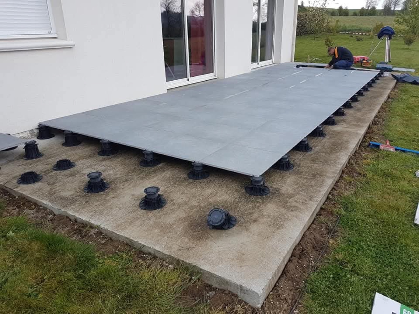 Pose de dalles sur plots réglables pour terrasse sur-mesure — chantier Dagicour en Normandie