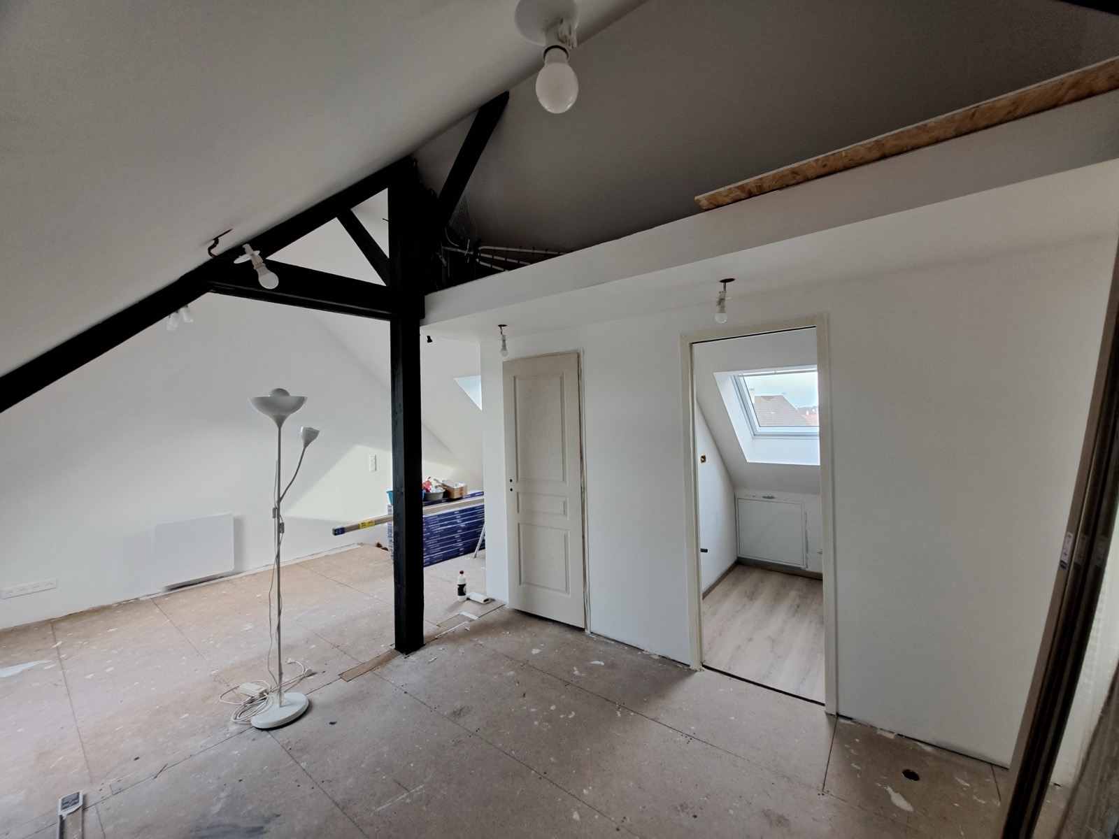 Enfilade de pièces sous combles avec poutre d'ossature noire et mezzanine, aménagement Dagicour